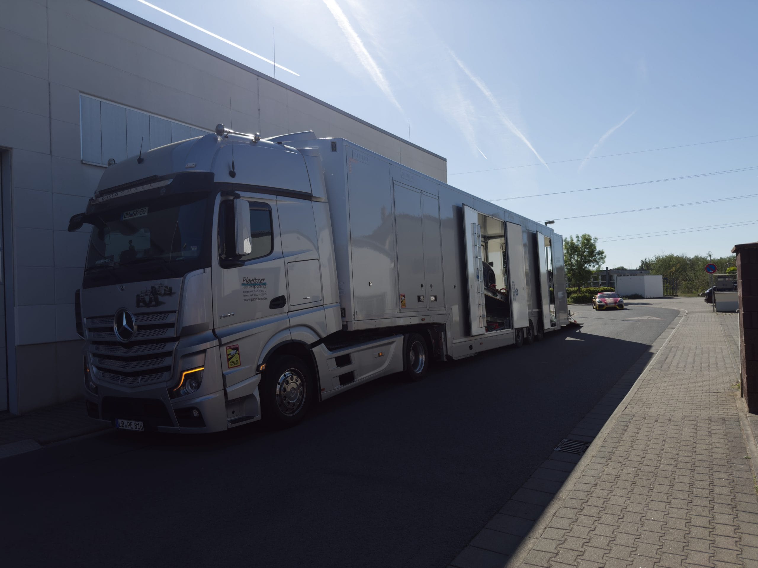 Geschlossener Fahrzeugtransporter vor dem CarIndustries Standort