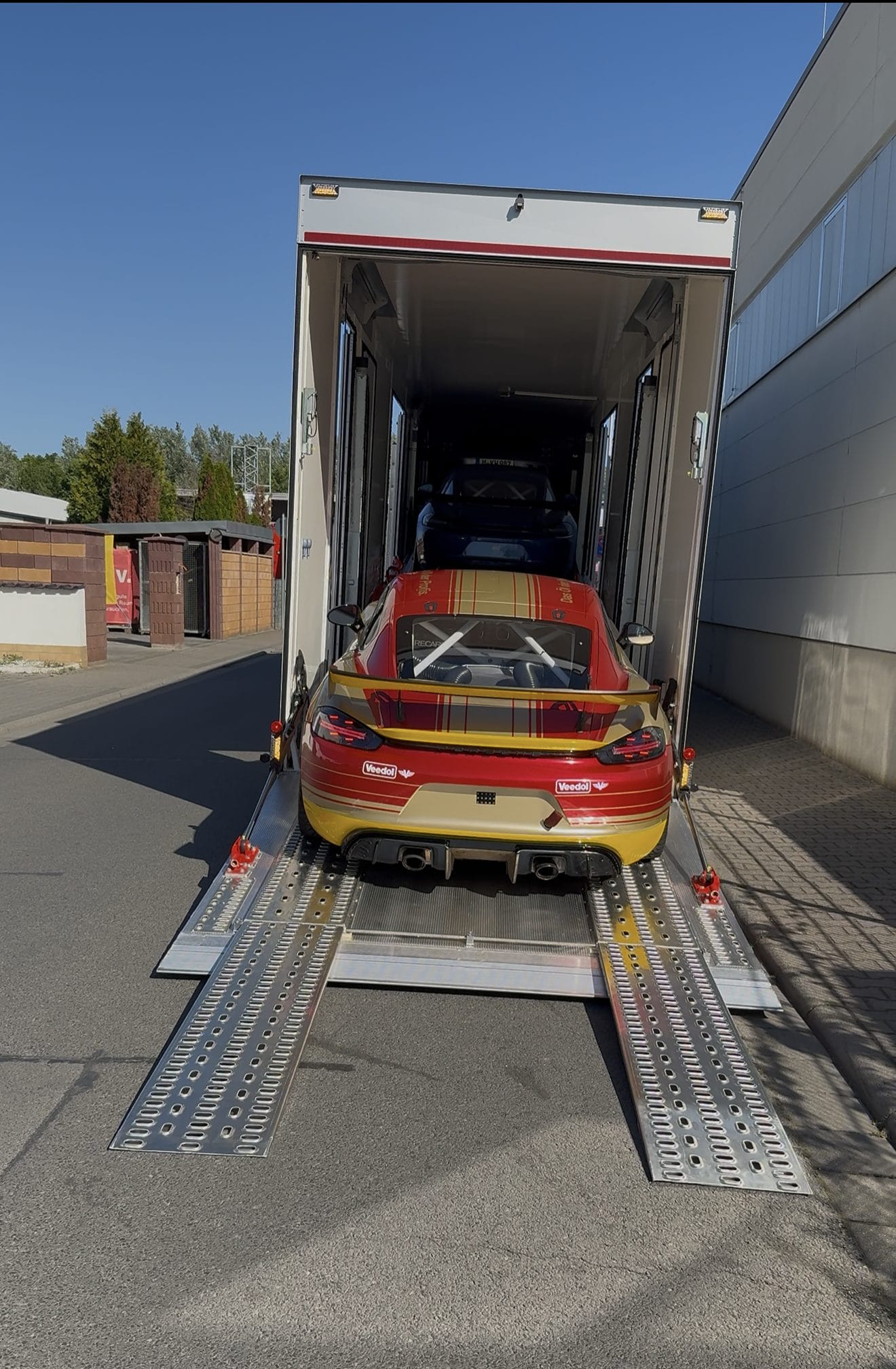 Rennfahrzeuge im geschlossenen Fahrzeugtransporter beim Verladen